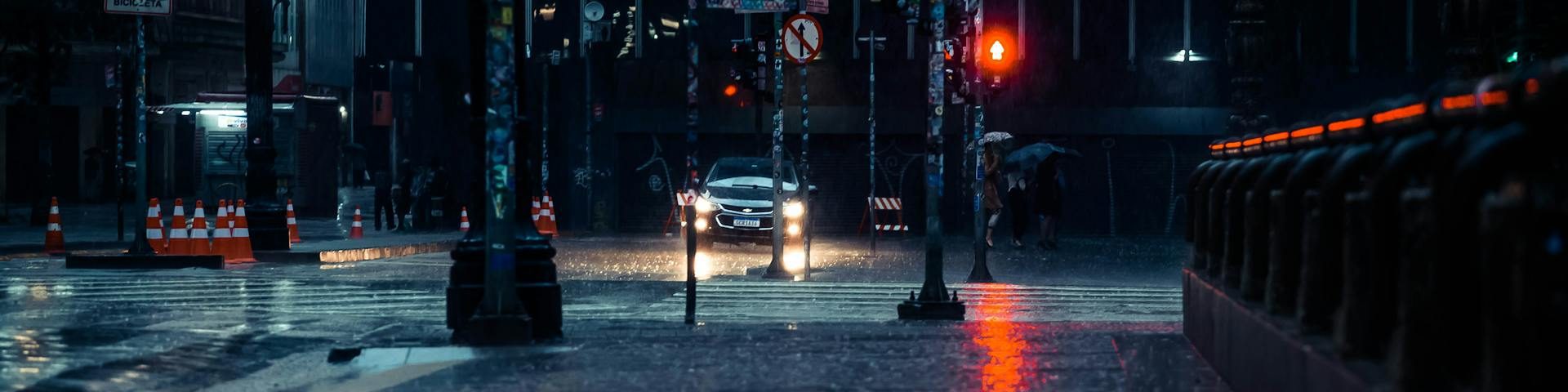 Pedestrian being splashed by a passing car on a wet street