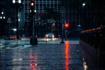Pedestrian being splashed by a passing car on a wet street