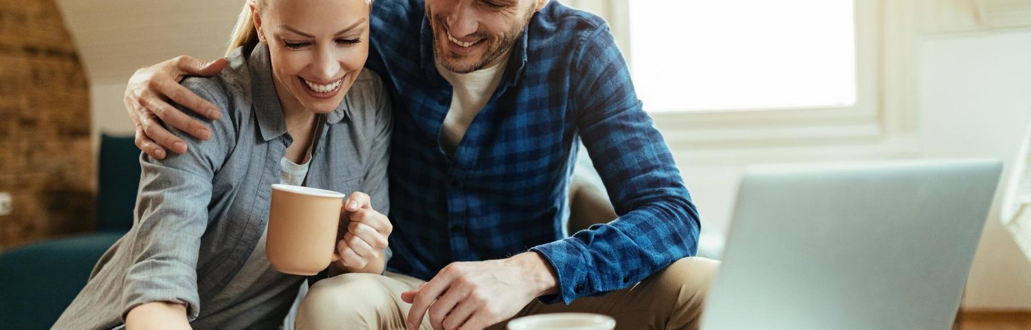A young couple discussing life insurance options with a financial advisor in a bright modern home office.