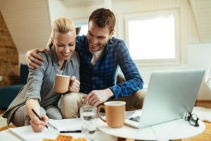 A young couple discussing life insurance options with a financial advisor in a bright modern home office.